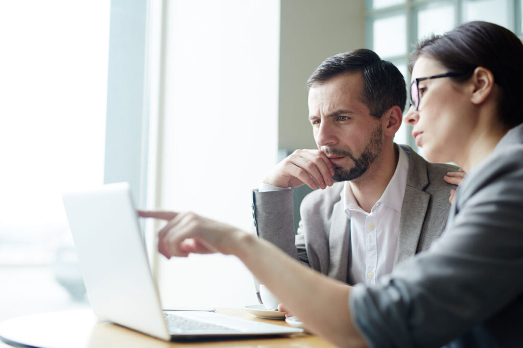 Two serious individuals closely examine a report related to a DOL audit.